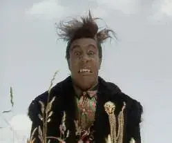 Red Dwarf S03E01 Backwards. Image shows Cat at the end of the episode, in the grass to have a shit before entering Starbug. But being the backward planet, where everything happens backward, Cat is shown with an unpleasantly surprised look on his face, with messed up hair